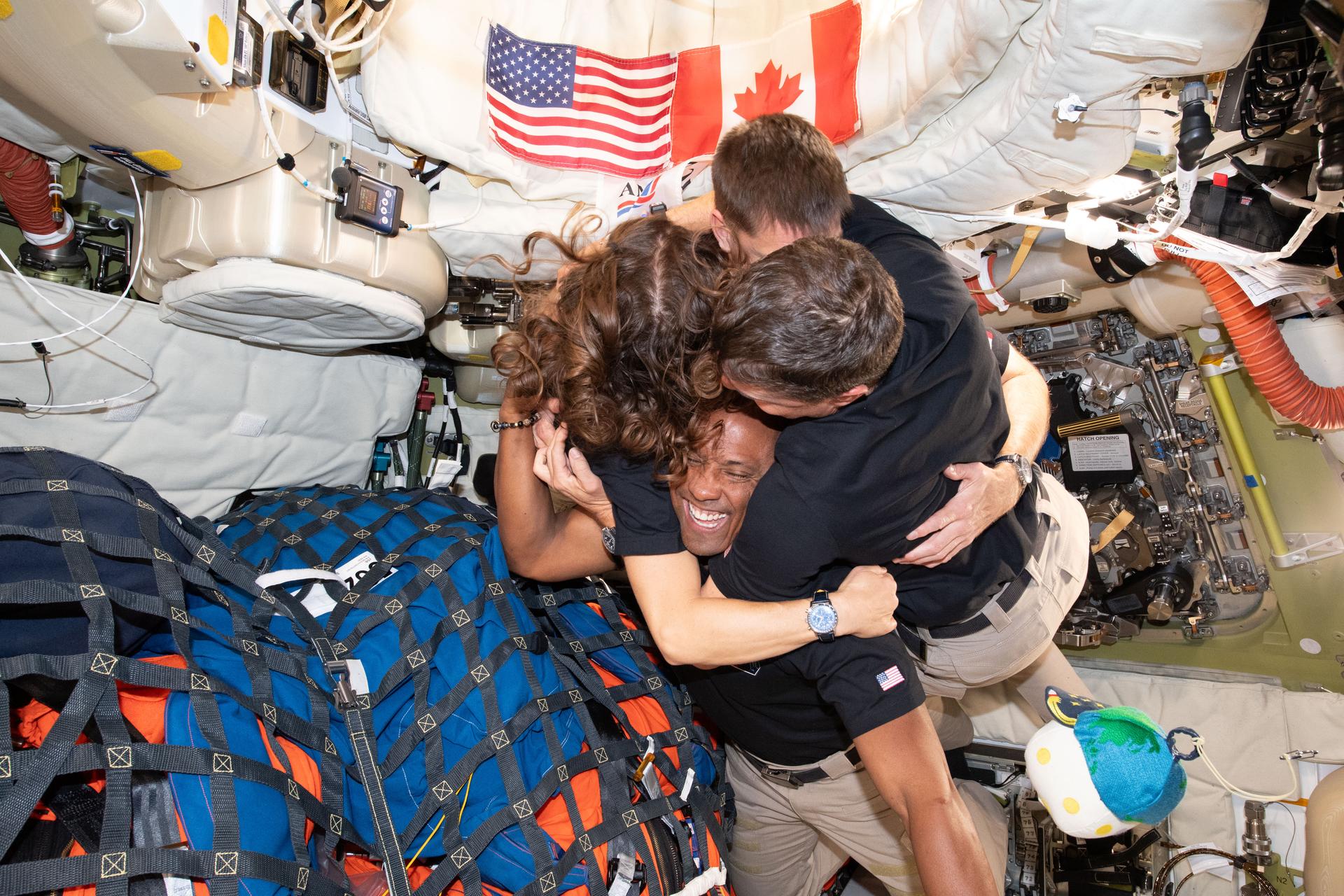 The Artemis 2 astronauts hugging each other inside the Orion spacecraft